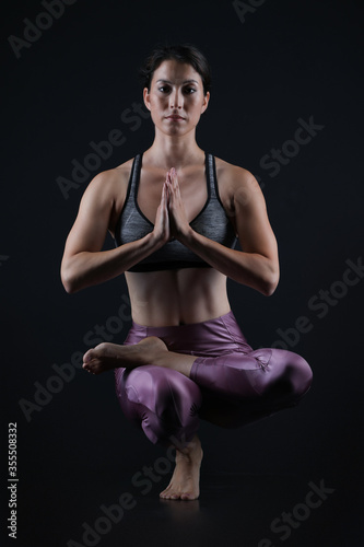Woman doing yoga in dark background