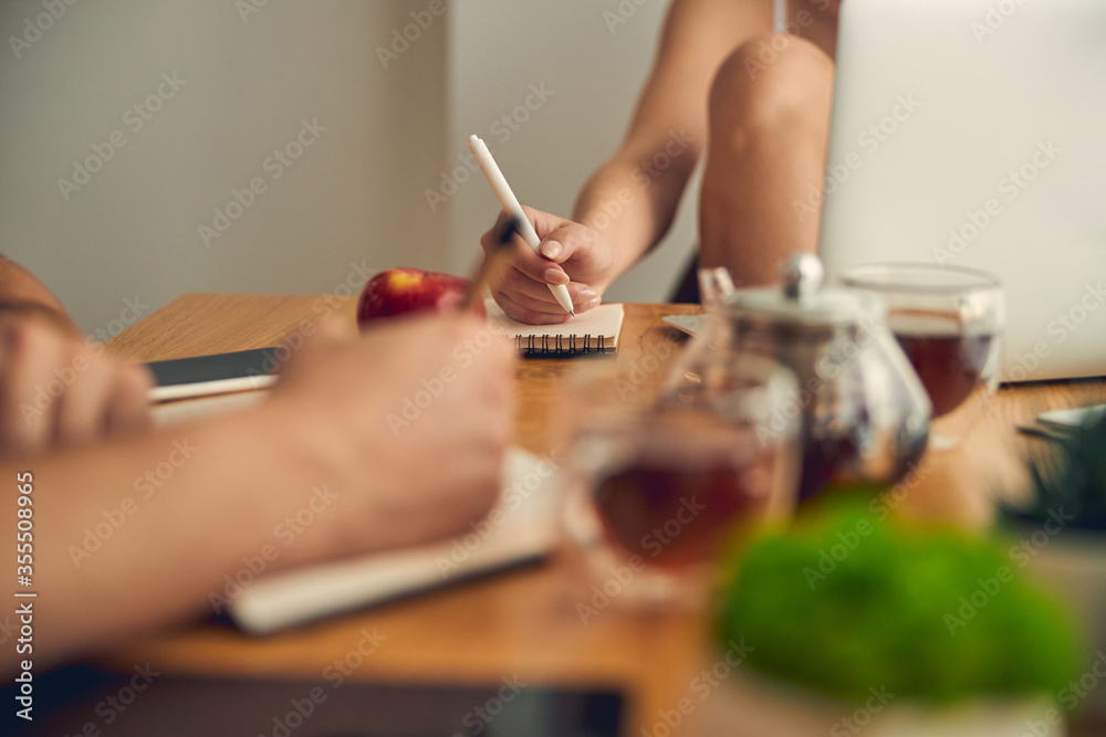 Hand of woman with coloured nails writing