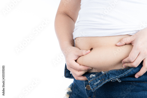 Fat woman holding excessive fat belly, overweight fatty belly isolated on over white background. Diet lifestyle, weight loss, stomach muscle, healthy concept. © saran