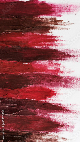 Swatch of red and burgundy lipsticks on a white sheet.