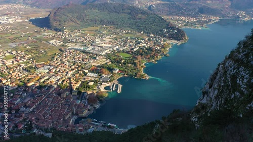Aerial video with drone, view of the beautiful Riva del Garda town and Lake Garda lake surrounded by mountains in the autumn time , Trentino Alto Adige region, Lago di garda, italy