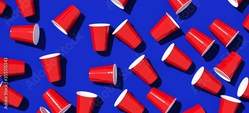 Minimal creative composition for beverage and party concept. Red plastic solo drinking cup on blue background. 3d rendering illustration. Object isolate clipping path included. photo