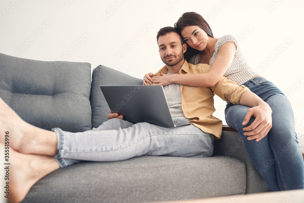 Happy young couple in love hugging on a couch Happy young couple in love hugging on a couch