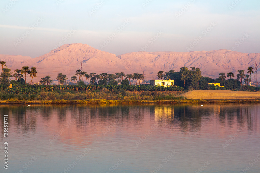 Nile river at sunrise with hot air balloons in Luxor, Egypt.
