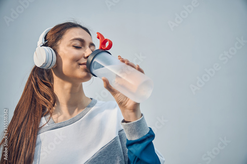 Bilde på lerret Sportive Caucasian lady restoring her water balance