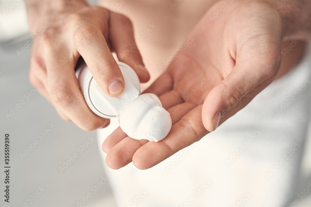 Hands of a man pouring some shaving foam out of dispenser Hands of a man pouring some shaving foam out of dispenser
