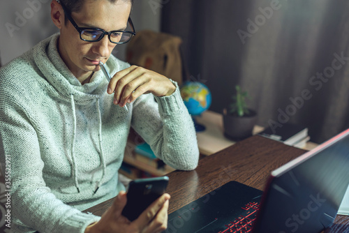 Man is working remotely using a laptop. A comfortable and convenient workplace at home for different professionals