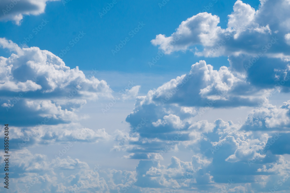 Fototapeta premium Many large fluffy clouds flat below, filled the bright blue sky. Can be used to illustrate paradise or heavenly city.