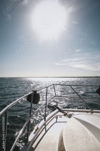 yacht sailing on a sunny summer day. Close-up view from the deck to the bow and sails. Clear blue sky.  © abramov_jora