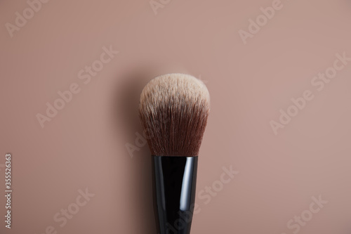 professional face makeup brush on beige background, close view, beauty concept 