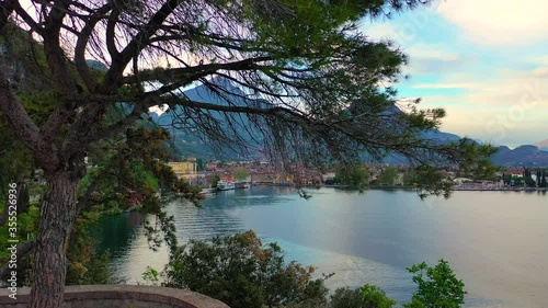 Aerial video with drone, view of the beautiful Riva del Garda town and Lake Garda lake surrounded by mountains in the autumn time , Trentino Alto Adige region, Lago di garda, italy