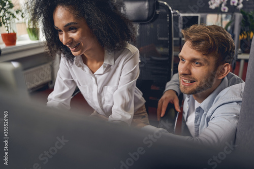 Two colleagues gazing at the computer monitor