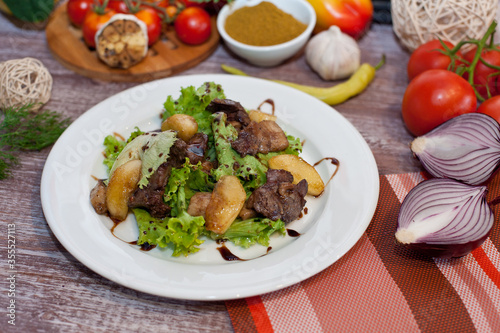 Salad with meat and pears on a white plate