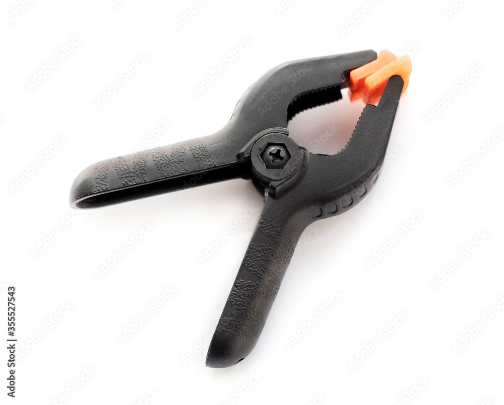 black plastic clip on a white background. repair tool. Top view black plastic clip on a white background. repair tool. Top view