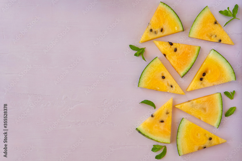 Sliced yellow watermelon on pink background. Top view Sliced yellow watermelon on pink background. Top view