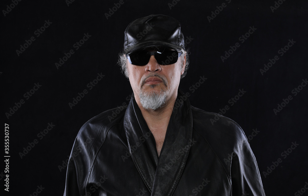 old bearded man in leather clothes on a black background old bearded man in leather clothes on a black background