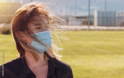 young woman with a mask. Woman wearing face mask during coronavirus outbreak. Virus spread flu prevention carantine. Girl in a facemask photo