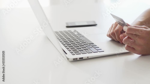 Asian man hand holding credit card using Labtop paying with credit card and entering security code for online shoping making, online shopping concept.