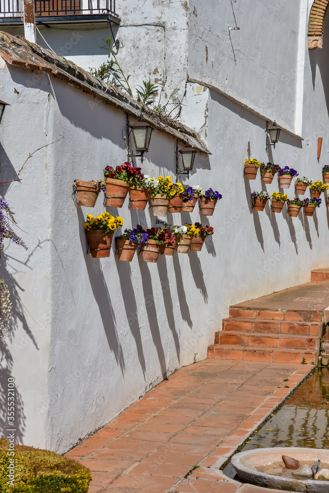 Multicolored pottery and flowers on a white wall in Spain