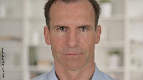 Close Up of Serious Middle Aged Businessman Looking at Camera