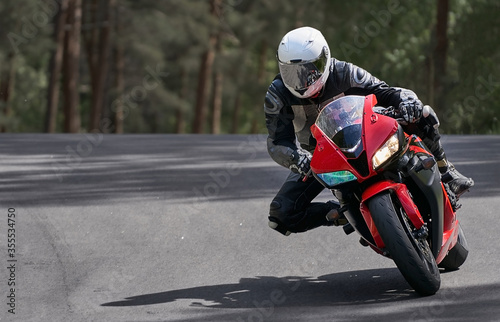 Fotografie Motorcyclist goes on road