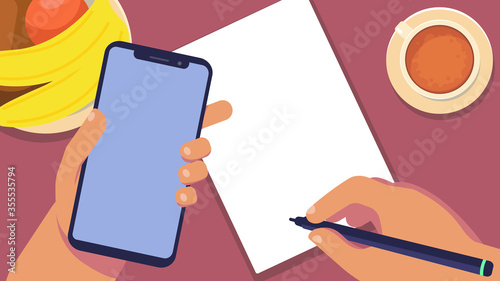 Top view on the table. Phone in hand, white sheet of paper, hand keeps notes. Breakfast in a slave setting. Shopping list. Calorie Counting.