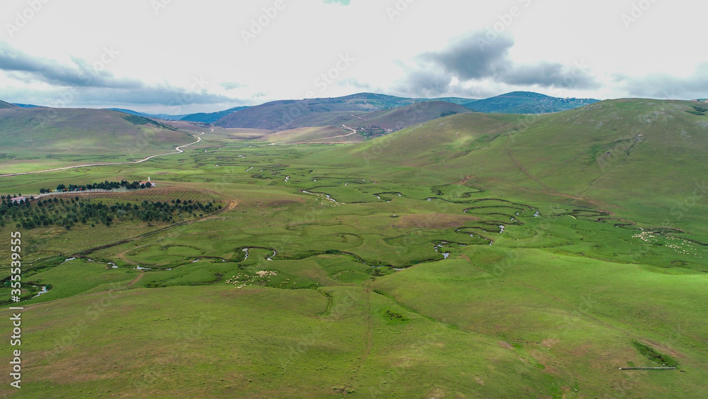 Meandering stream with mountains and clouds at The Persembe Plateau at Ordu, Turkey Drone and Aerial view