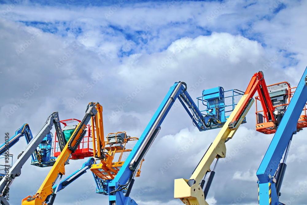 Aerial work platforms, AWP, also known as an aerial device, elevating work platform, EWP, bucket truck or mobile elevating work platform, are lifted up in a row. Aerial work platforms, AWP, also known as an aerial device, elevating work platform, EWP, bucket truck or mobile elevating work platform, are lifted up in a row.