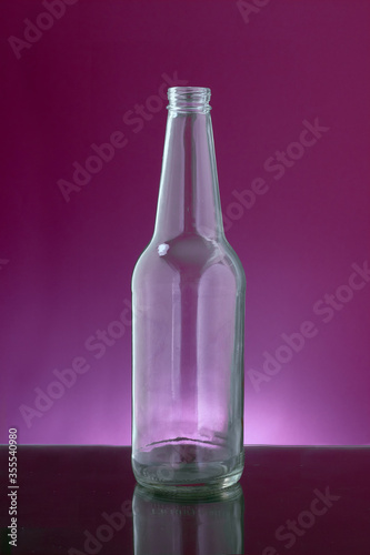 transparent beer bottle in purple background