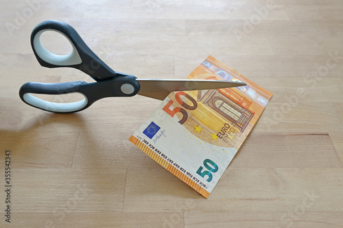 фотографія Business concept, fifty Euro banknote is cut with scissors, symbol for wage redu