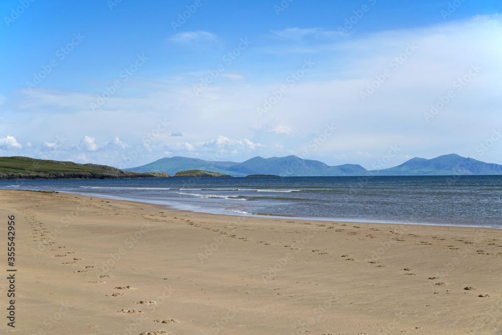 Footprints in the sand on a deserted beach at Aberffraw, Anglesey, Wales, UK
