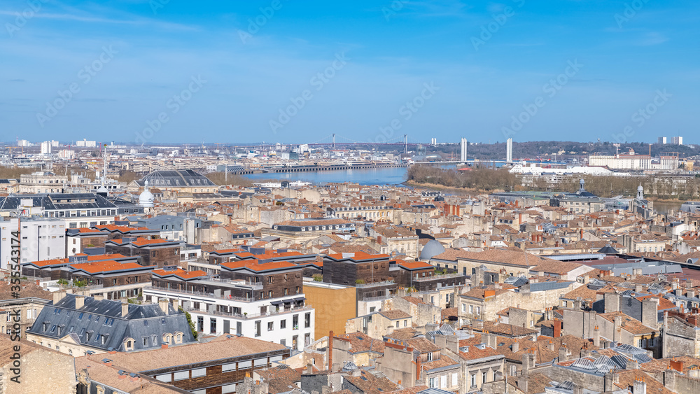 Bordeaux, beautiful french city, typical tiles roofs in the center, with the Garonne river in background
