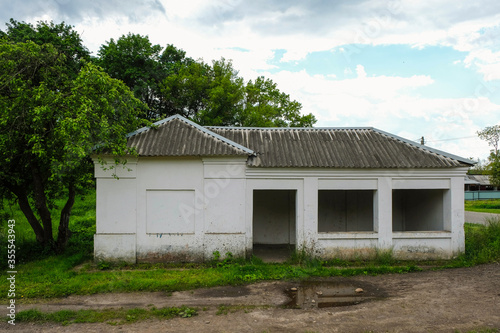 White old building with a slate roof on the platform of the railway station in the Ukrainian village.