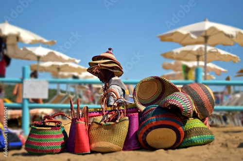 street vendor of bags on the beach of Baratti in Tuscany, Italy