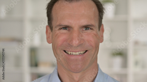 Close Up of Cheerful Middle Aged Businessman Smiling at Camera