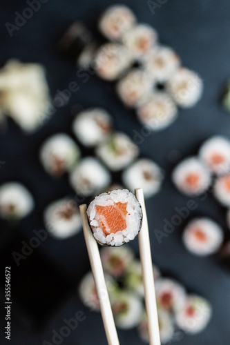 Roll with salmon in sushi sticks