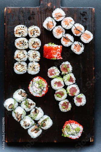 Set of rolls and sushi. Rolls and sushi on a dark brown board. Rolls with red caviar, with salmon, with tuna. 