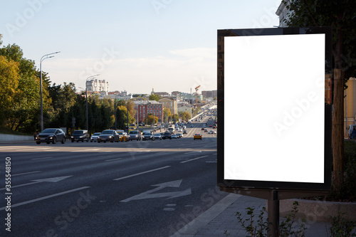 Billboard at the roadway on the sidewalk in the city.