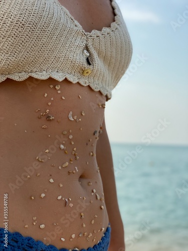 body fragments in pebbles of a beautiful girl on the beach near the sea