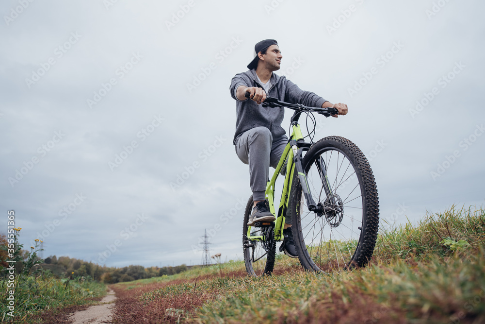 A man on a bicycle in the autumn on a field road A man on a bicycle in the autumn on a field road