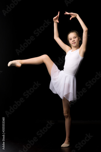 Full length portrait of a charming gymnast girl in elegant dress.