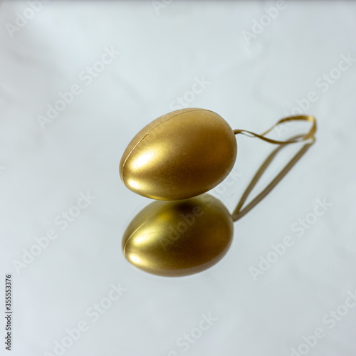Golden egg on the mirrors. Christmas tree toy. Easter decoration.