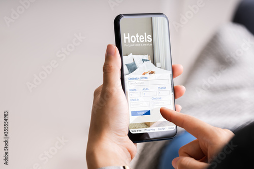 Holding Smart Phone Booking Hotel Online