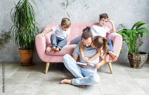 Happy father's day. Cute young father is reading a book to his children. Happy family togetherness and fatherhood. Children spend time with their father. photo