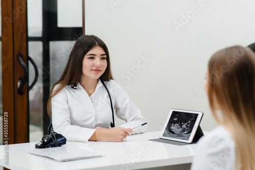 A young couple at a gynecologist's consultation after an ultrasound. Pregnancy, and health care