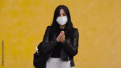 Young woman with mask disinfect his hands