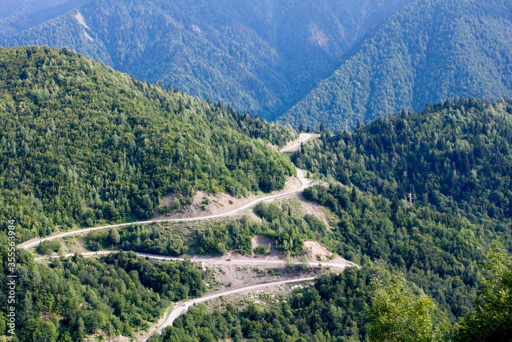 Beautiful green natural landscape of mountains covered with forest in Svaneti region in Georgia, Europe. Winding mountain road.