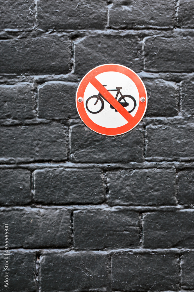 no bike parking sign on black brick wall. do not park your bicycle here no bike parking sign on black brick wall. do not park your bicycle here