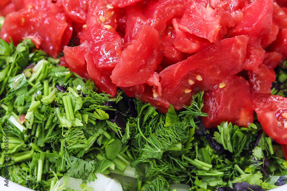 Sliced tomatoes and sliced greens for salad closeup. Sliced tomatoes and sliced greens for salad closeup.