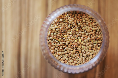 Lentils inside a bowl on a wooden table. View from above.